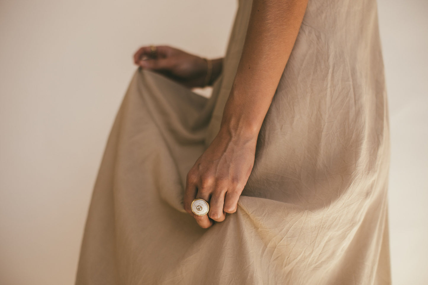A MODELS LEFT HAND WEARING THE 18K GOLD PUKA RING WITH DIAMOND-ONE-OF-A-KIND-WHITE