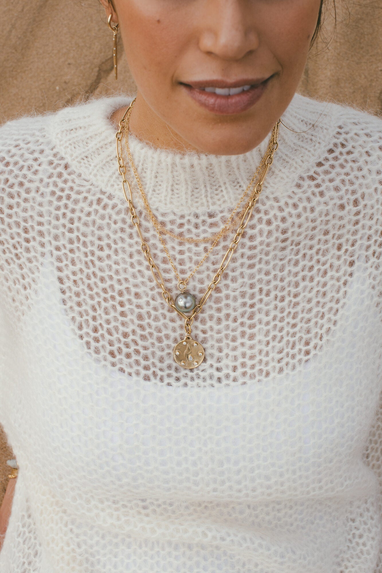 THE LARGE GOLD HORN SHELL CHARM WITH DIAMONDS AROUND A MODELS NECK