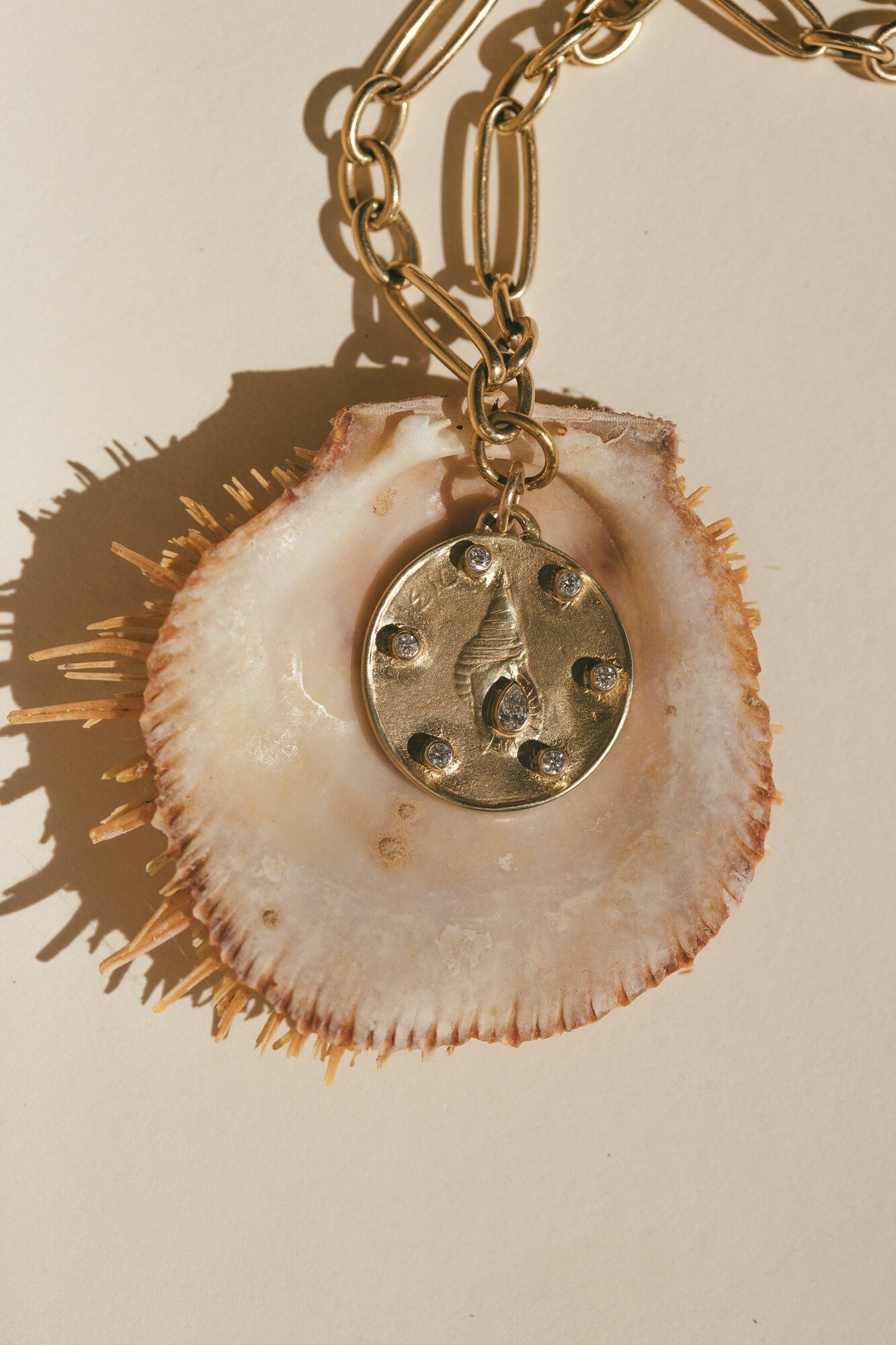 A CLOSE UP OF THE LARGE GOLD HORN SHELL CHARM WITH DIAMONDS