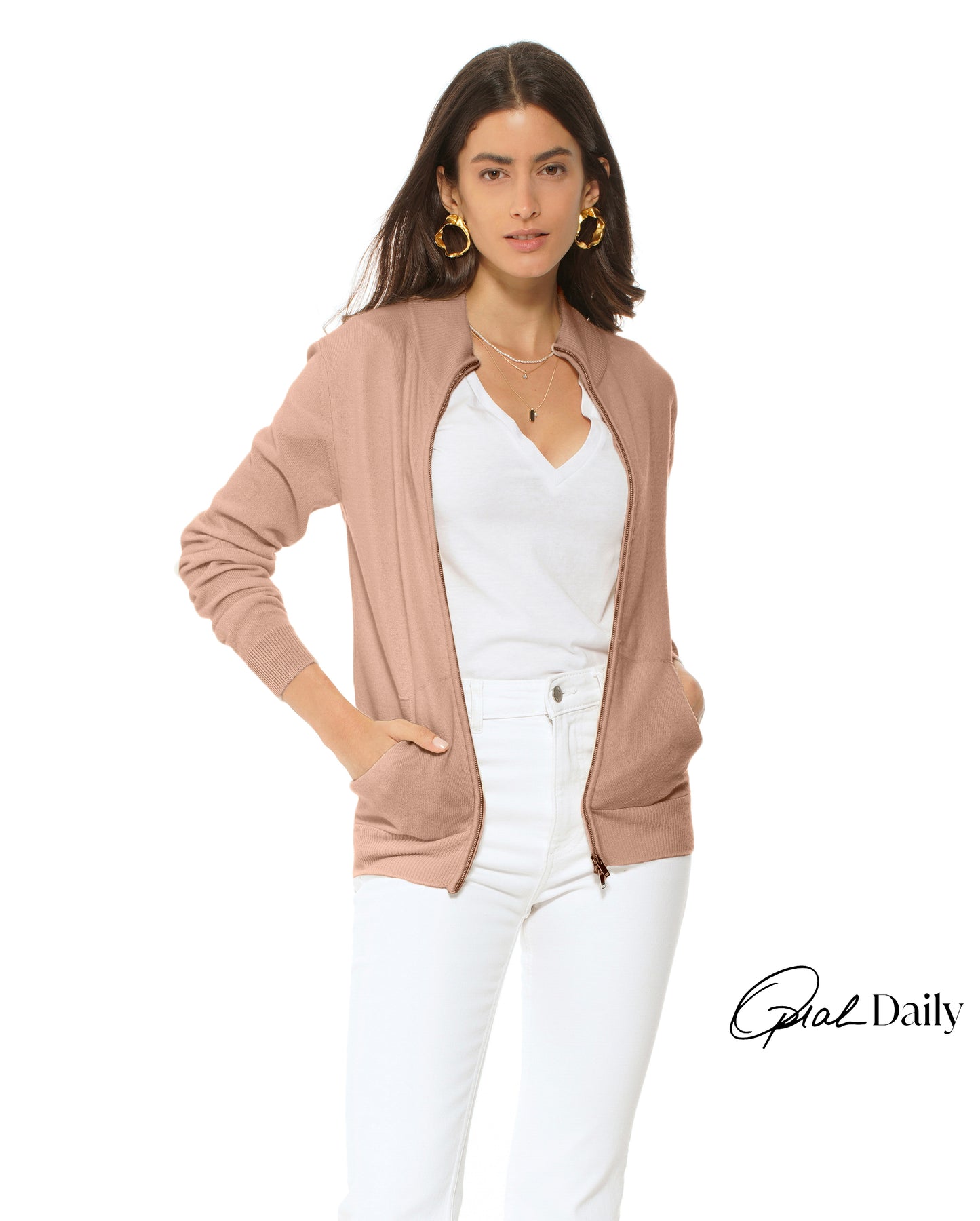 Woman wearing a beige cardigan over a white top and pants on a white background