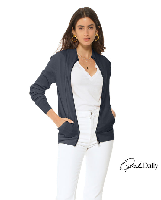 Woman wearing a navy cardigan over a white top and pants on a white background