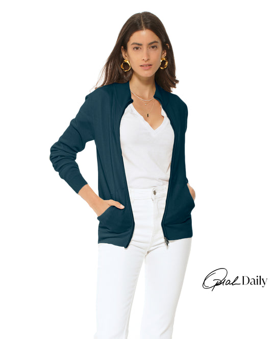 Woman wearing a navy cardigan over a white top and pants on a white background