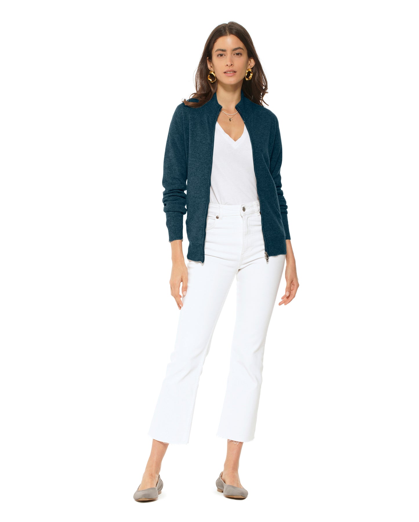 Woman wearing a navy cardigan, white top, and white pants on a white background