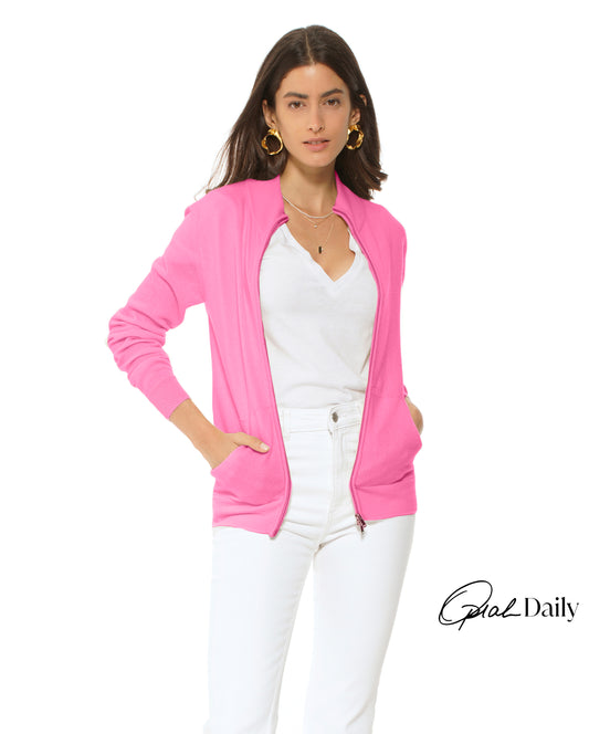 Woman wearing a pink cardigan over a white top and pants on a white background