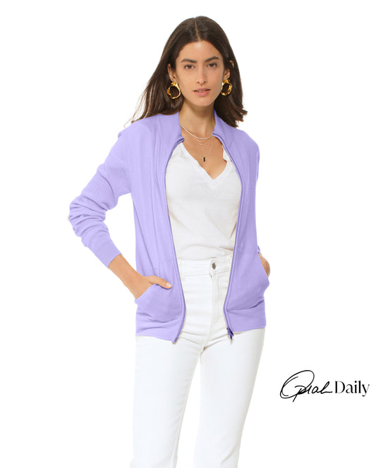 Woman wearing a light purple cardigan over a white top and pants on a white background