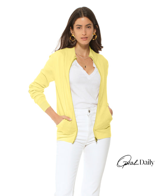 Woman wearing a yellow cardigan over a white top and pants on a white background