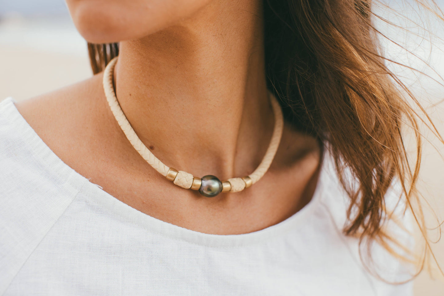 THE MOMI 14K GOLD CHOKER WITH TAHITIAN PEARL AROUND THE MODELS NECK