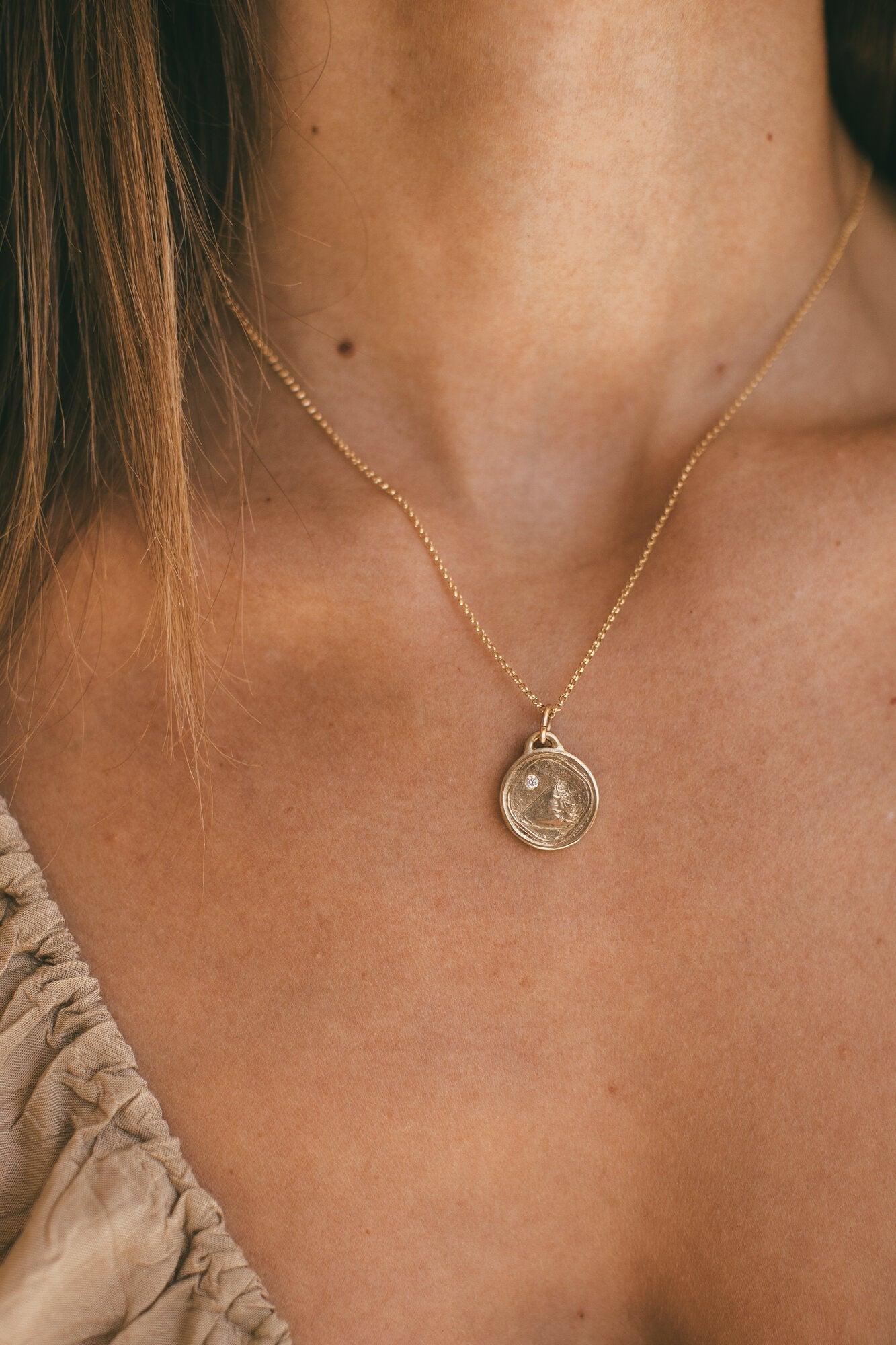 THE SMALL GOLD CONCH SHELL CHARM WITH DIAMOND AROUND A MODELS NECK