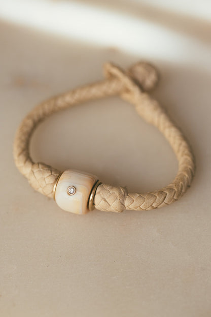 A CLOSE UP OF THE 14K GOLD VINTAGE CONCH WITH DIAMOND LEATHER BRACELET