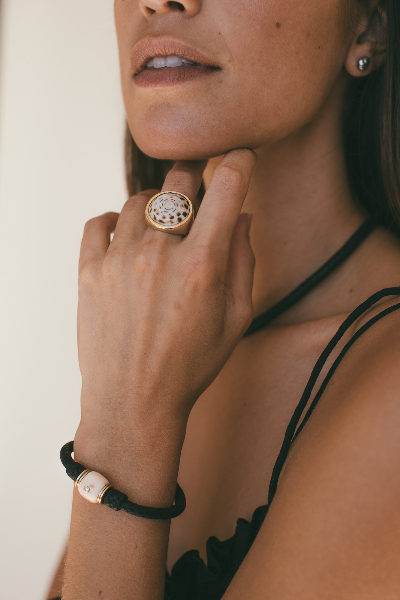 14K GOLD VINTAGE CONCH WITH DIAMOND LEATHER BRACELET ON A MODELS WRIST