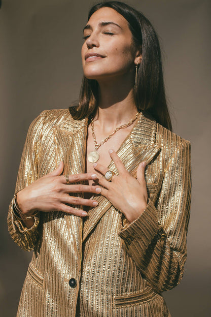 A MODEL FACING THE SUN WITH THE GOLD PALM TREE & DIAMOND COCONUT CHARM
 AROUND HER NECK 