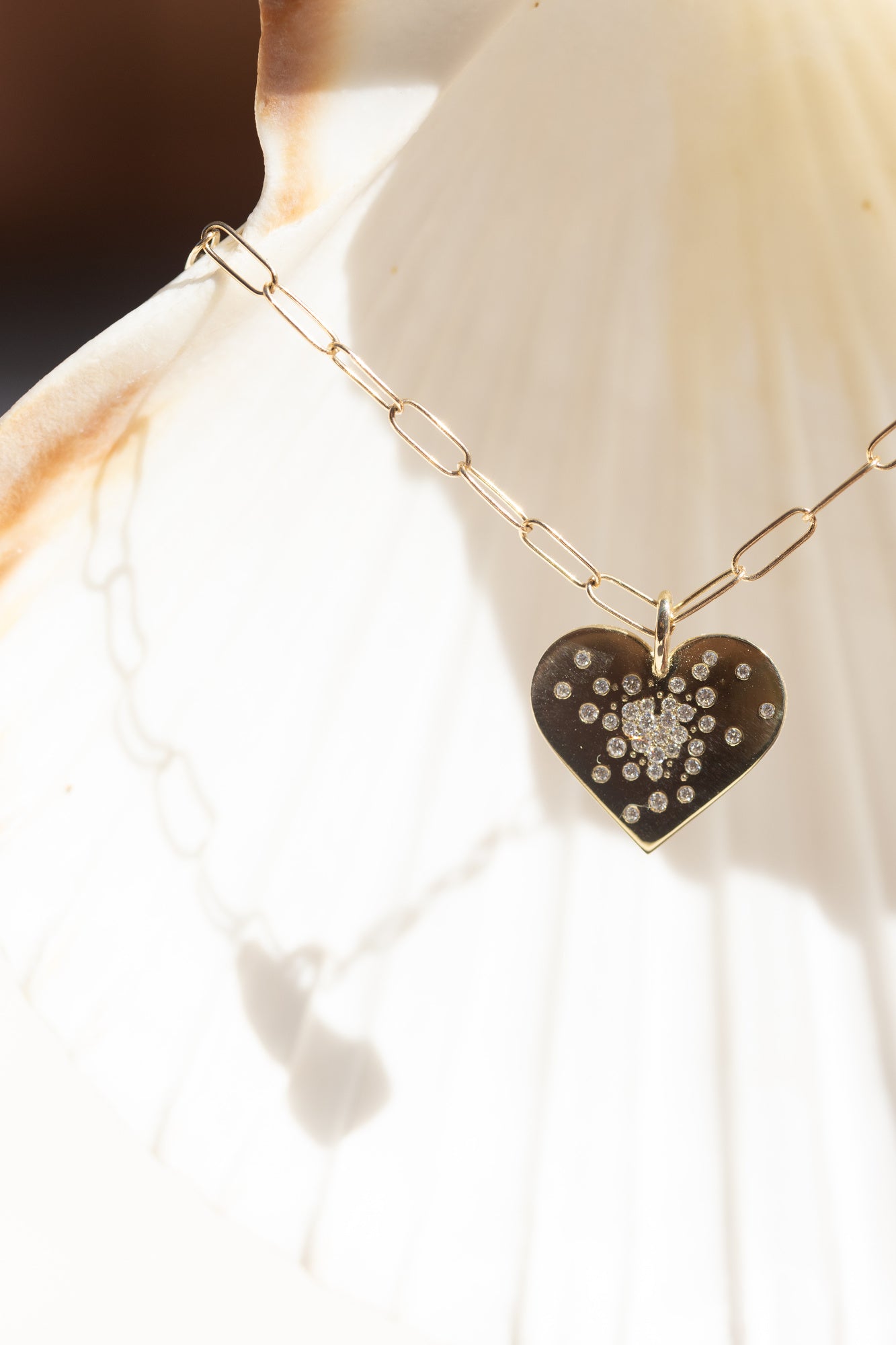 A CLOSE UP IMAGE OF THE GOLD HEART DIAMOND BURST CHARM