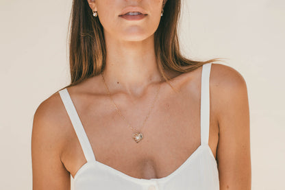 A MODEL WEARING THE GOLD HEART DIAMOND BURST CHARM