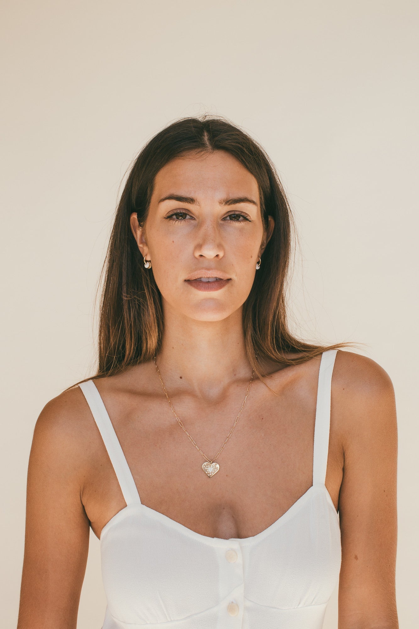 A FEMALE MODEL WEARING THE GOLD HEART DIAMOND BURST CHARM AROUND HER NECK