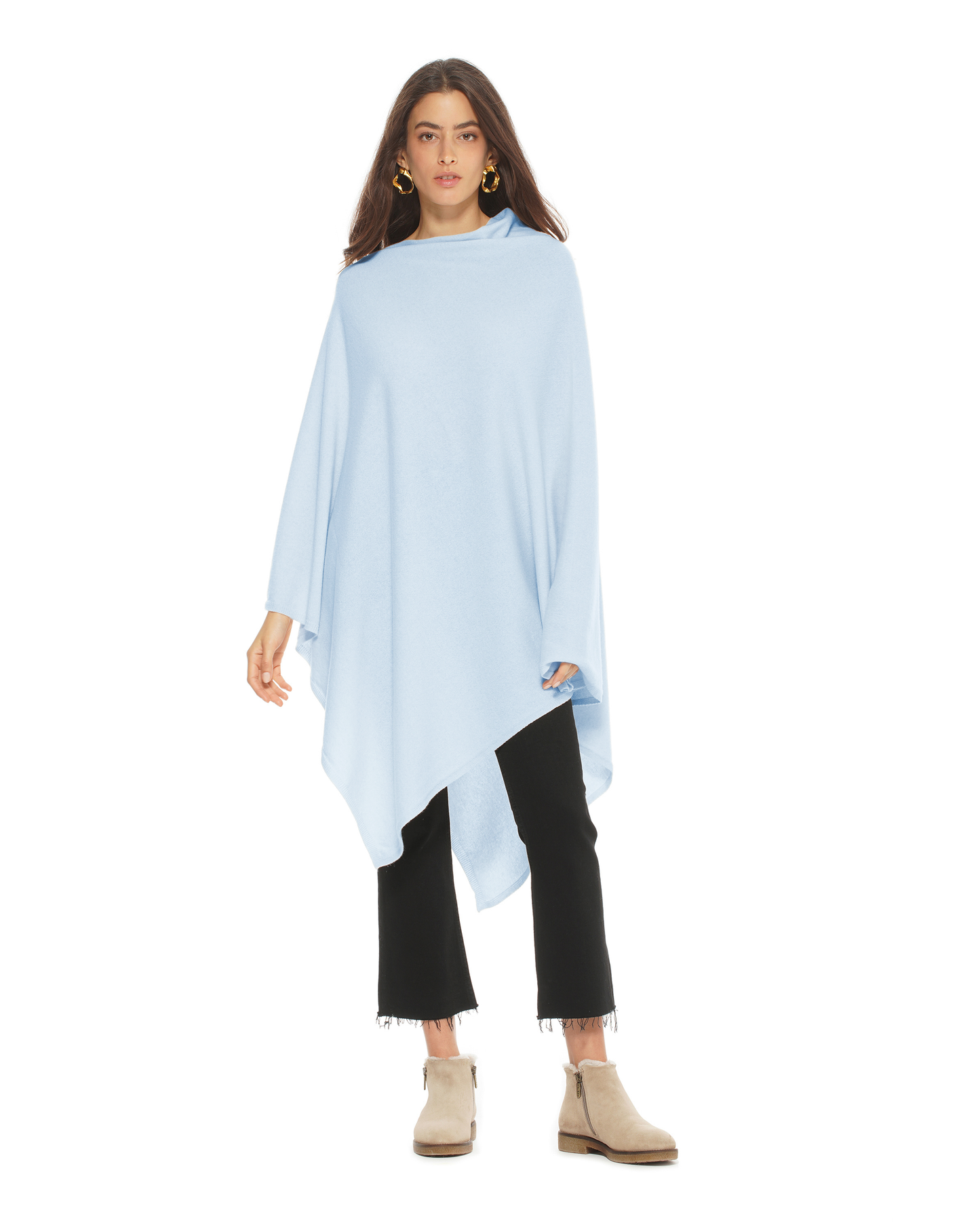 Woman wearing a light blue poncho over a black outfit on a white background