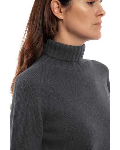 Women's cashmere raglan sleeve turtleneck sweater in Charcoal, close-up of the ribbed turtleneck and raglan shoulder