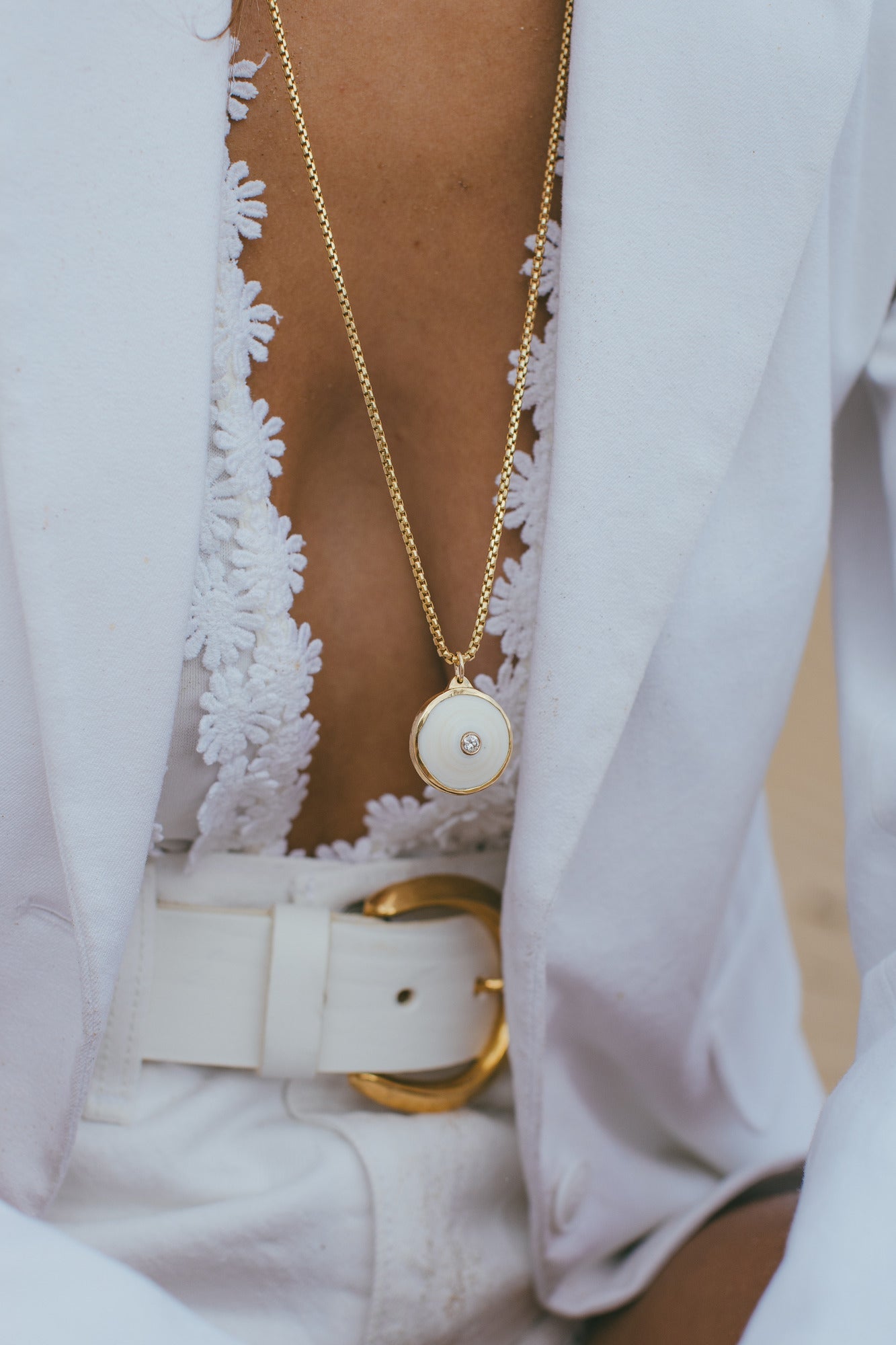 A CLOSE UP OF THE MEDIUM 18K GOLD PUKA CHARM WITH DIAMOND-ONE-OF-A-KIND-WHITE