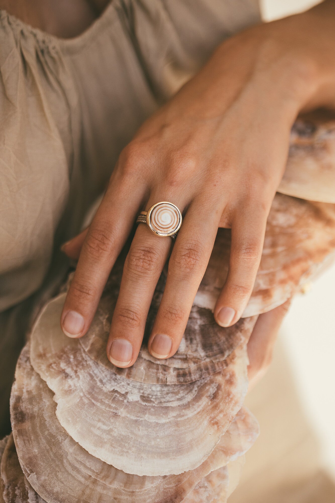 A CLOSE UP OF THE PUKA STACKING SWIRL RING-ONE-OF-A-KIND ON A MODELS HAND