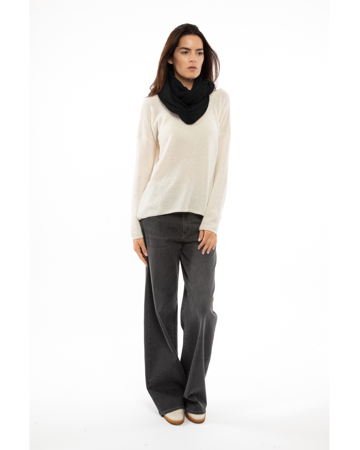 Black maxi cashmere infinity scarf wrapped around a model’s neck.