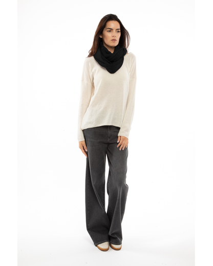 Black maxi cashmere infinity scarf wrapped around a model’s neck.