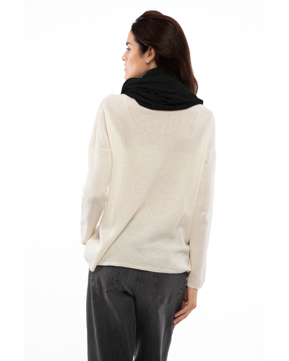 Black cashmere infinity scarf looped around a model’s neck, viewed from behind.