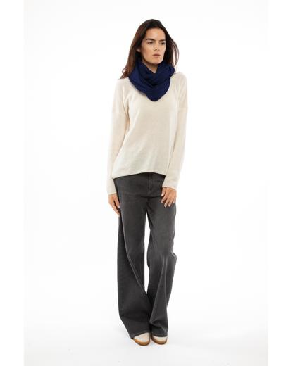 Blue maxi cashmere infinity scarf wrapped around a model’s neck.