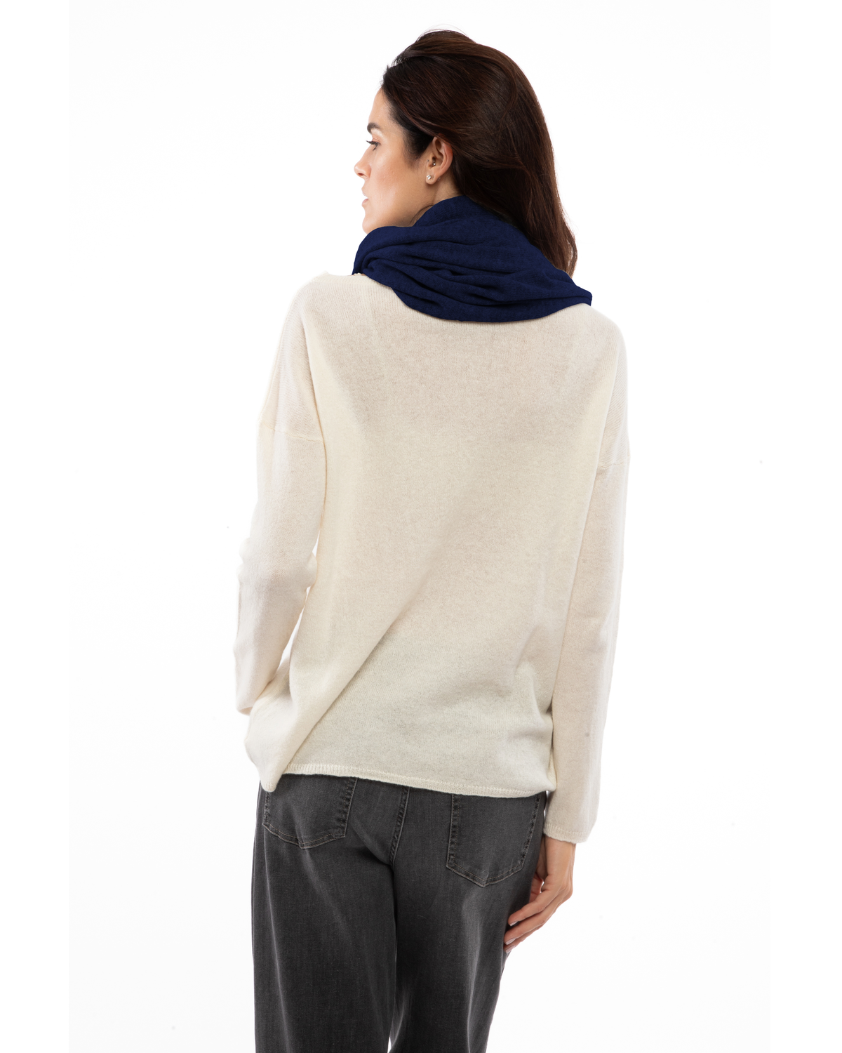 Blue cashmere infinity scarf looped around a model’s neck, viewed from behind.