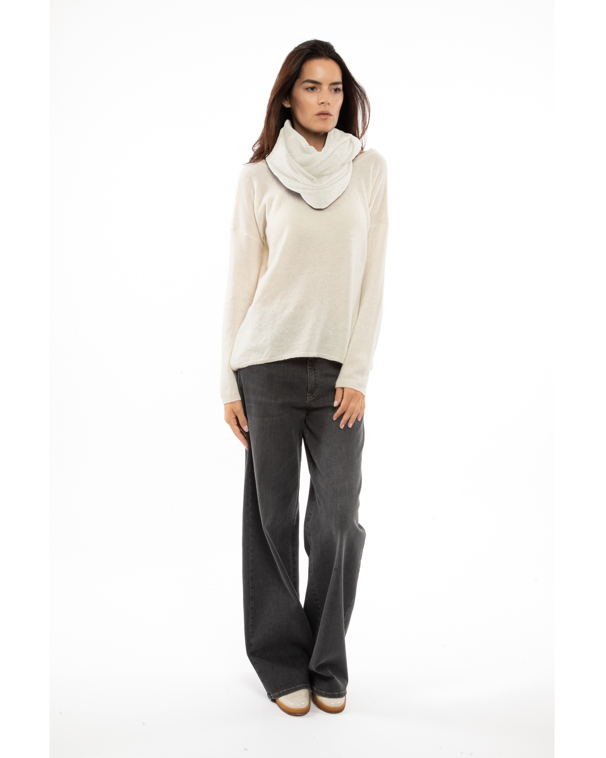 Milk white cashmere infinity scarf looped loosely around a model’s neck.
