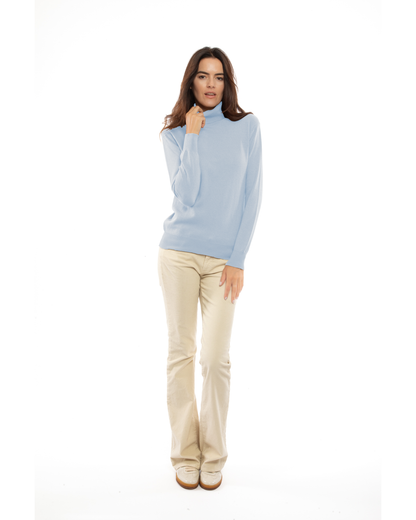 Model wearing a Baby Blue cashmere turtleneck sweater with light trousers, full-length front view.
