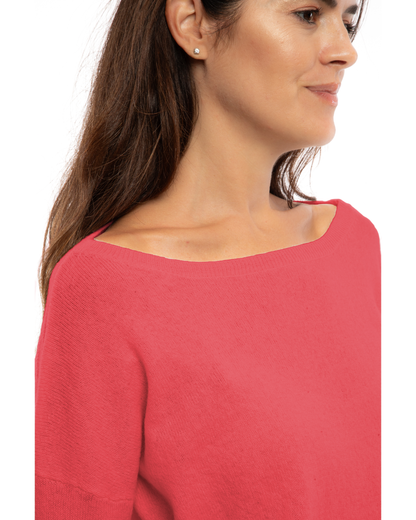 Coral Red oversized pure cashmere boatneck sweater, close-up of the wide boat neckline and cashmere texture.