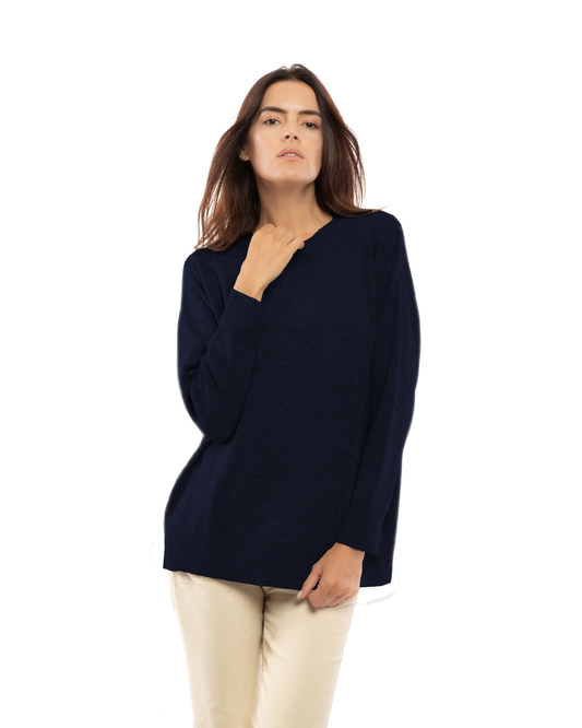 Night Blue cashmere oversized crewneck sweater, front view on a model with one hand at the neckline.