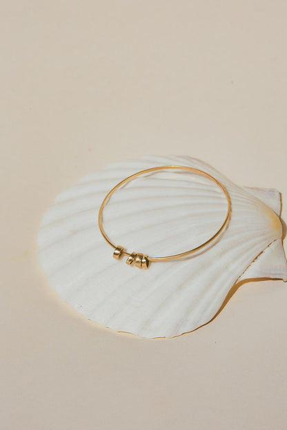 Quatro 14k bangle on sea shell