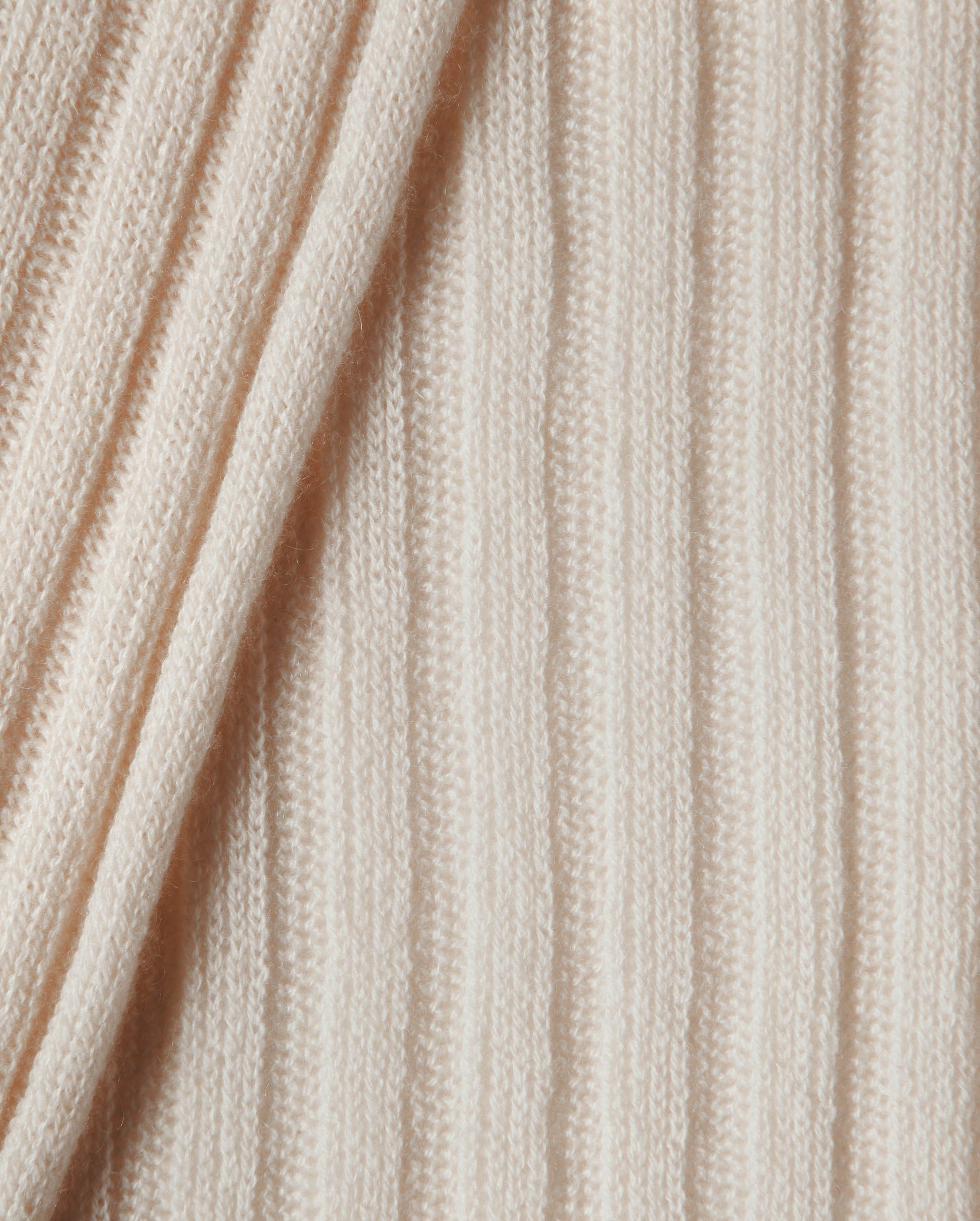 Close-up of beige knitted fabric with visible texture